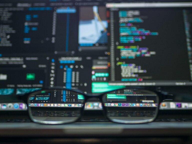 Services 4 Eyeglasses reflecting computer code on a monitor, ideal for technology and programming themes.