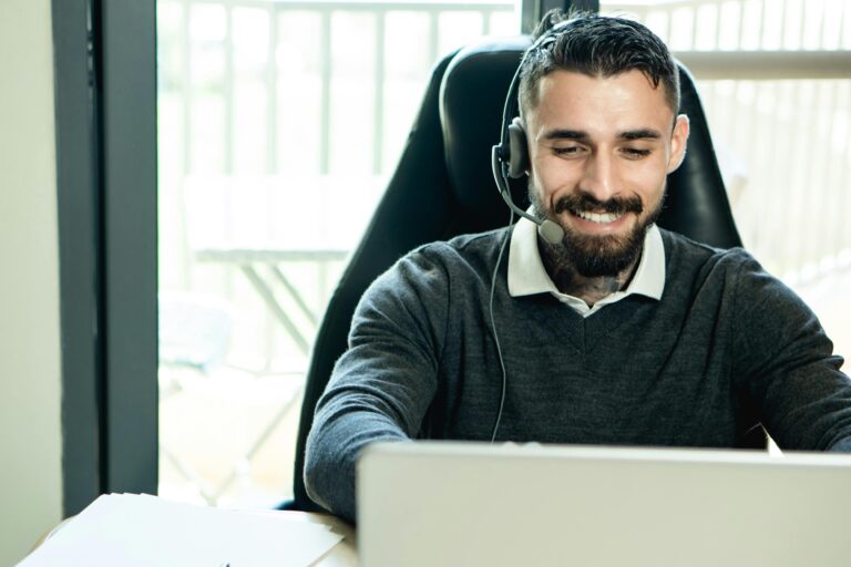 Services 3 A friendly customer support agent wearing headphones, working in an office environment.