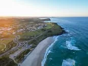 Stunning aerial view of Ballina, NSW coast, showcasing sandy beaches and a vibrant town at sunset.
